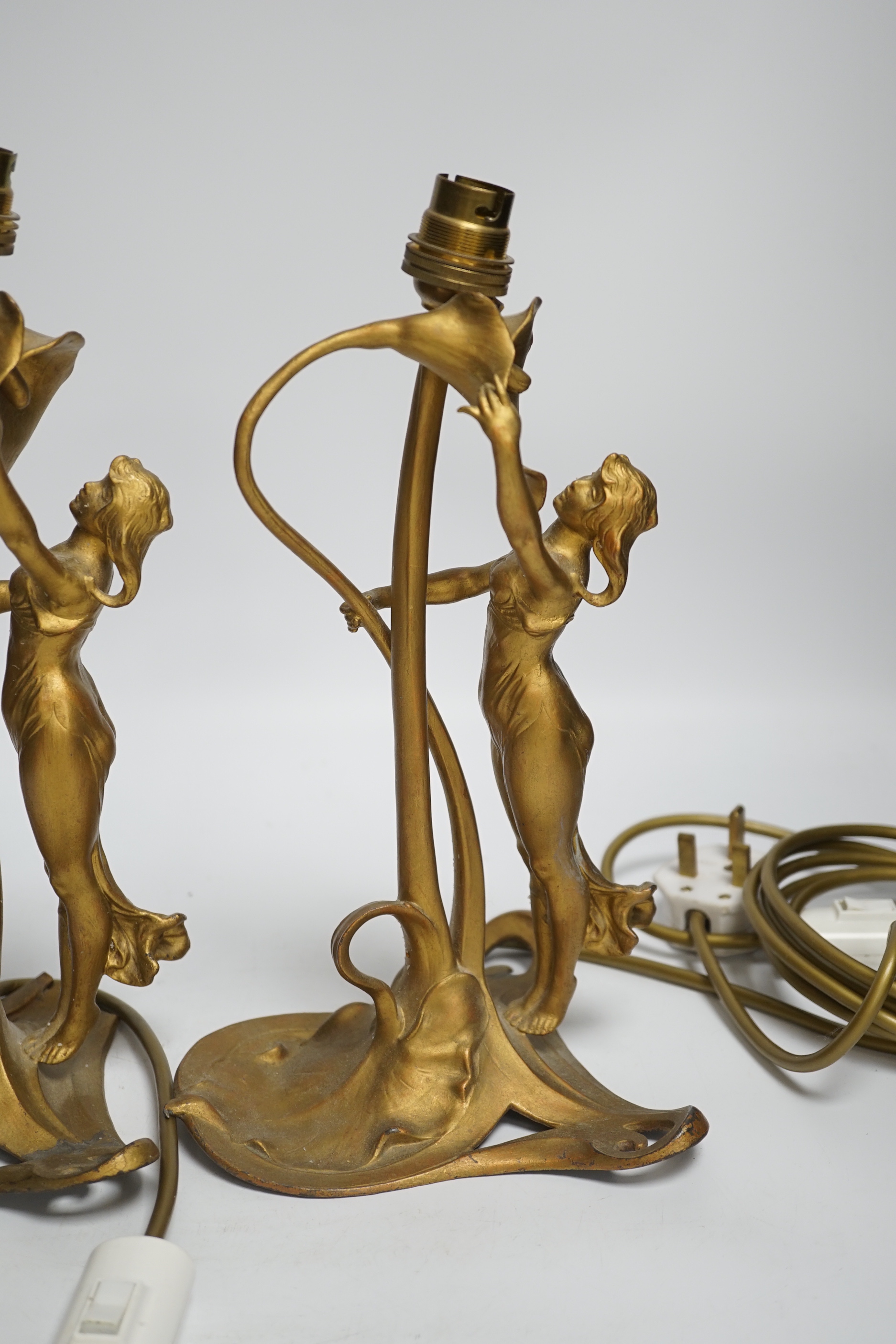 A pair of Christopher Wray, Art Nouveau style lily and figural gilt metal table lamps, 26cm high